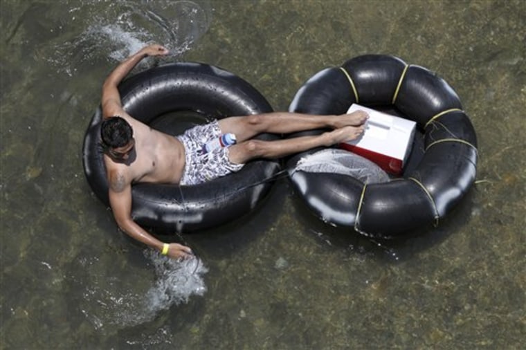 In a May 28, 2012 photo, a tuber floats down the Comal river Memorial Day in New Braunfels, Texas. Drinking beer while lazily floating through New Braunfels is a heat-beating tradition for hundreds of thousands of vacationers each summer, but turnout is down and businesses say the reason is clear: a new ban on disposable containers. 